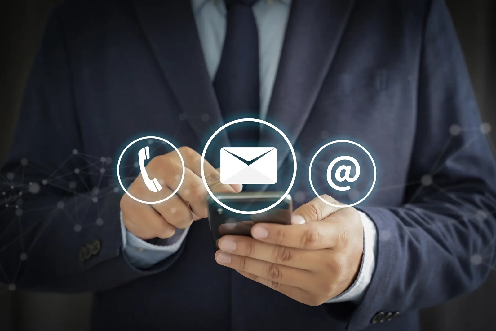 A person holding a mobile phone, with phone, email and message symbols shown alongside.